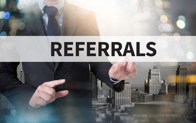 A man holding a sign that says referrals.